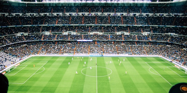 橄榄球运动员在雨中抱球冲锋，泥水飞溅